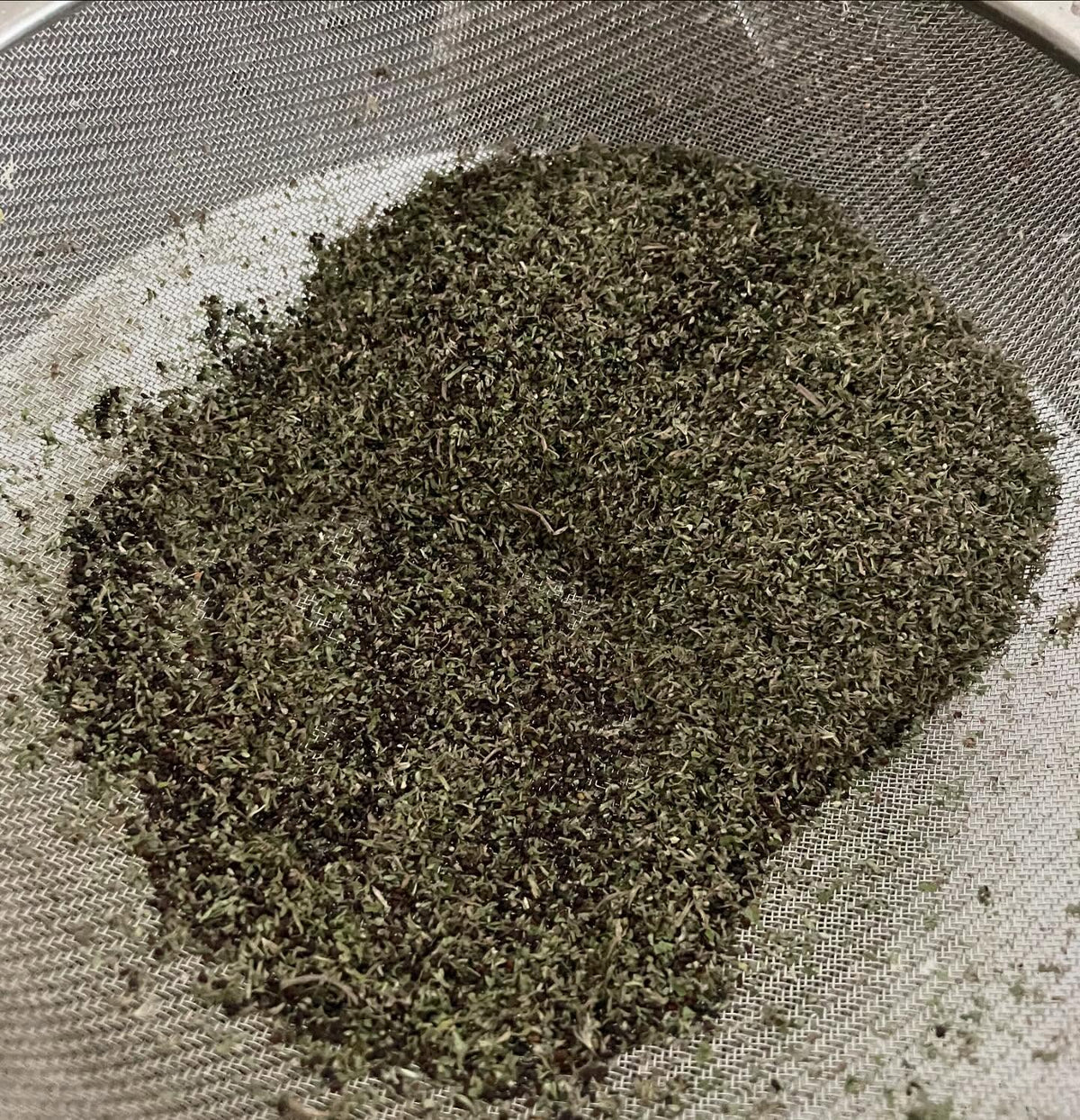 cleaning a brown shopping bag of catnip for seed, image 4 of 8