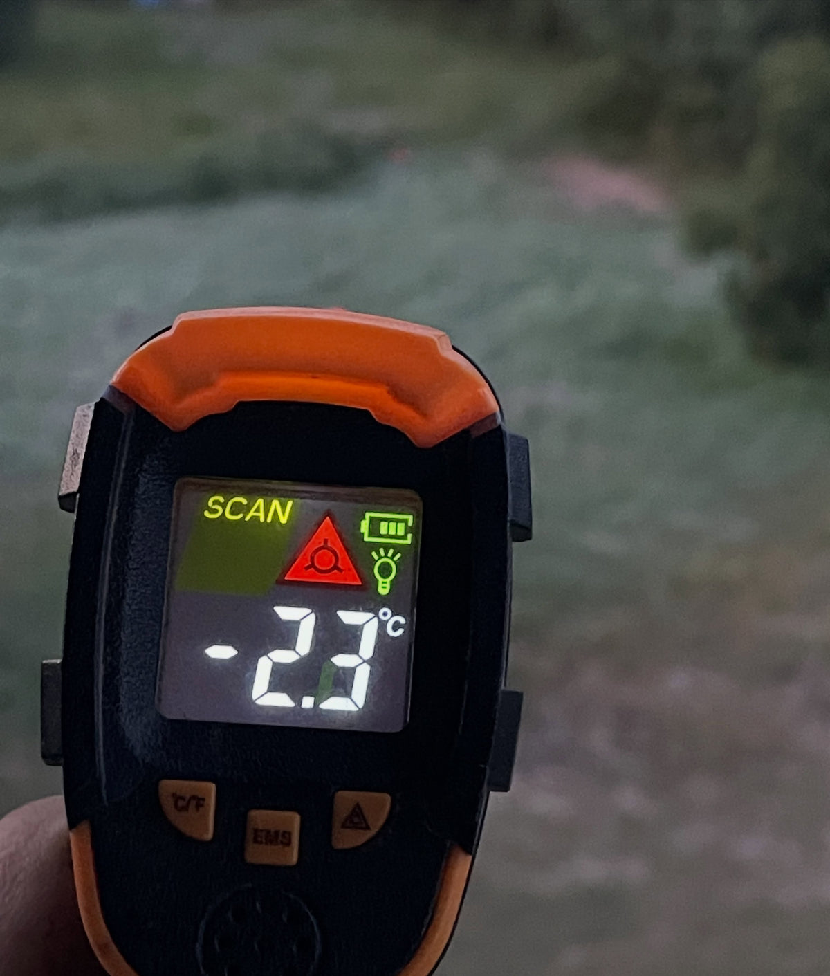 Handheld infrared thermometer displaying minus 2.3 degrees Celsius outdoors