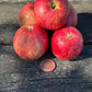 Sweet Konrad apples on a wooden table with a coin for scale. Photograph by: Konrad Ilg